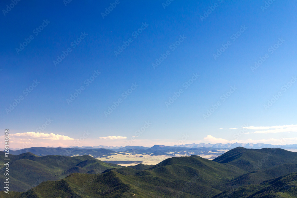 Green Forest Covered Mountain Wilderness and Clear Blue Sky Background in Colorado