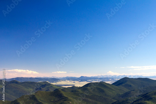 Green Forest Covered Mountain Wilderness and Clear Blue Sky Background in Colorado