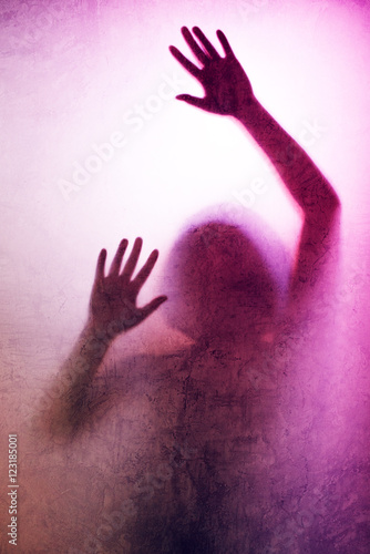 Trapped woman, back lit silhouette of hands behind matte glass
