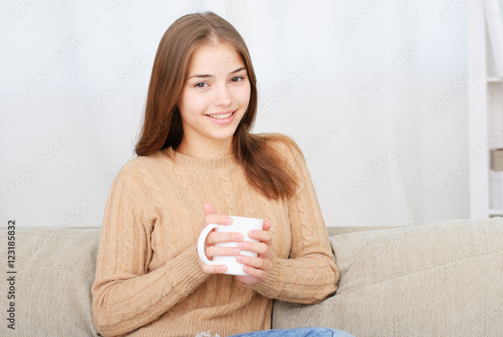 young woman sitting on couch and drinking coffee young woman sitting on couch and drinking coffee