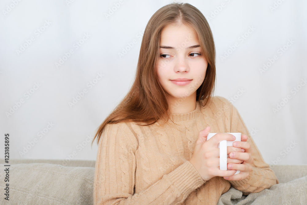 young woman sitting on couch and drinking coffee young woman sitting on couch and drinking coffee