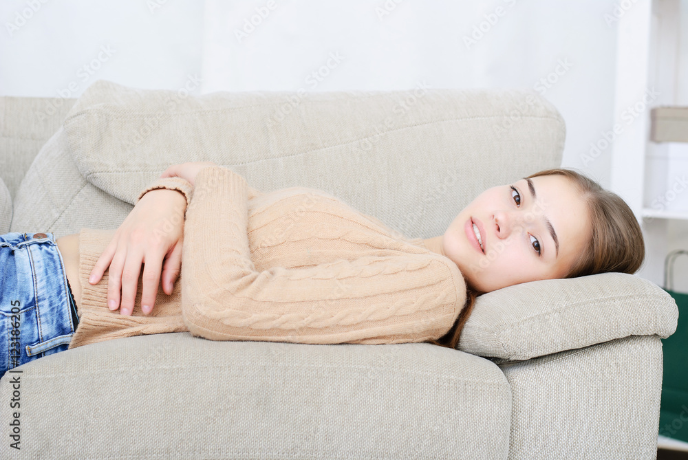 smiling young woman lying on couch smiling young woman lying on couch