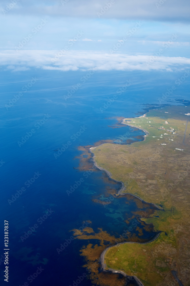 View from airplane window on the sea and coastline in Iceland