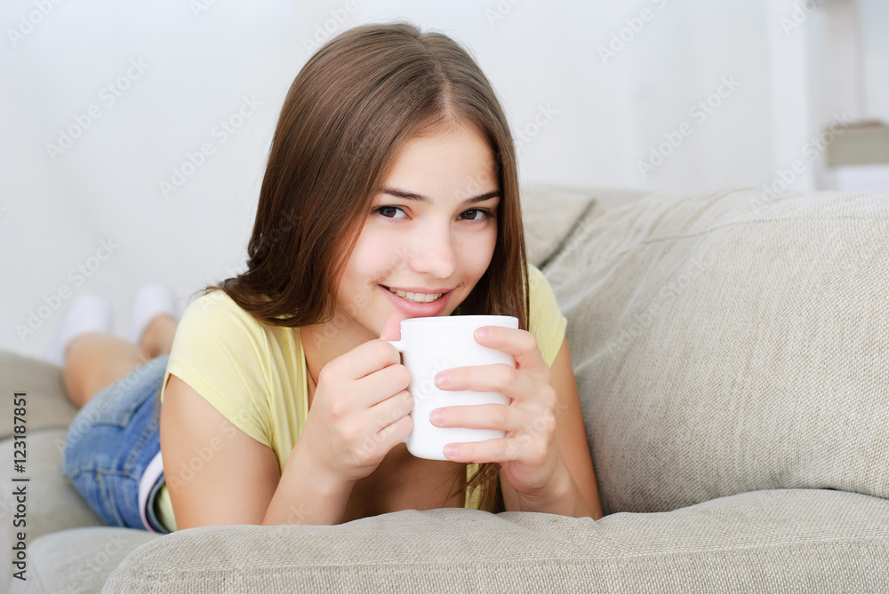 young woman sitting on couch and drinking coffee young woman sitting on couch and drinking coffee