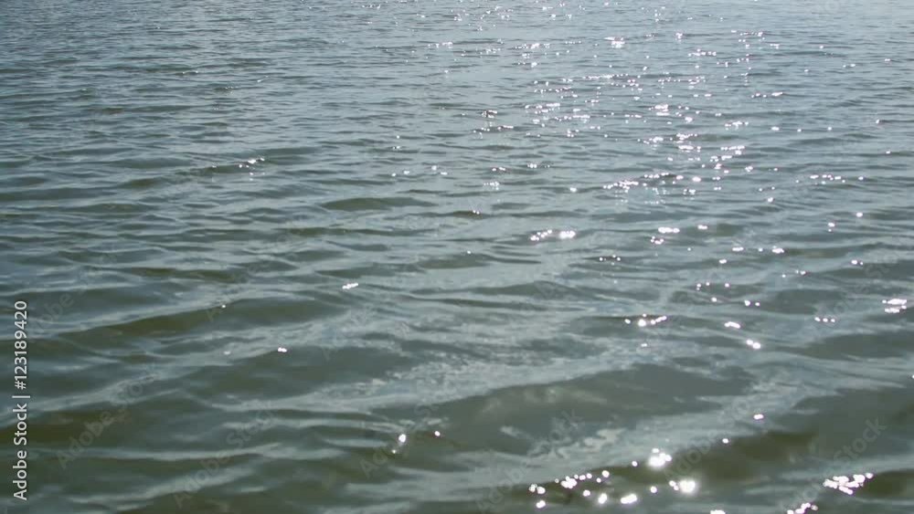 Water surface and sun reflection, in motion Water surface and sun reflection, in motion