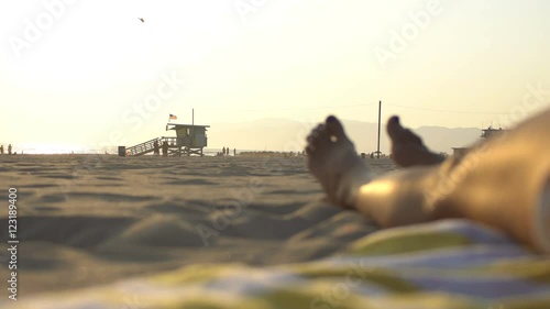 Woman relaxing on the beach at sunset, shot between Venice beach and Santa Monica in Los Angeles