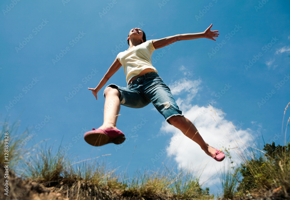 Image of girl in casual clothing jumping in the park Image of girl in casual clothing jumping in the park