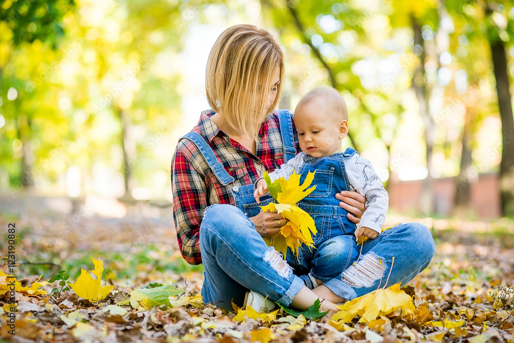 young mother playing with baby in the park in autumn young mother playing with baby in the park in autumn