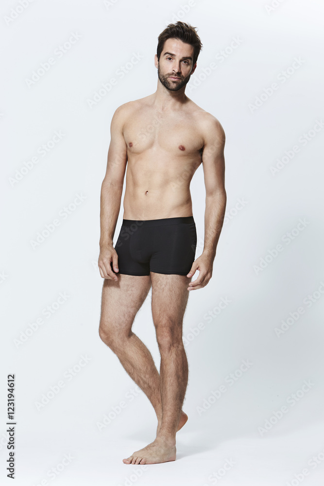 Guy in black underwear against white background