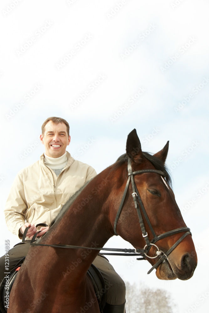 Obraz premium A handsome man riding a horse outside