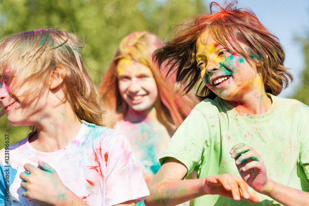 Fototapeta premium Cute kids smeared with colored powder on Holi fest