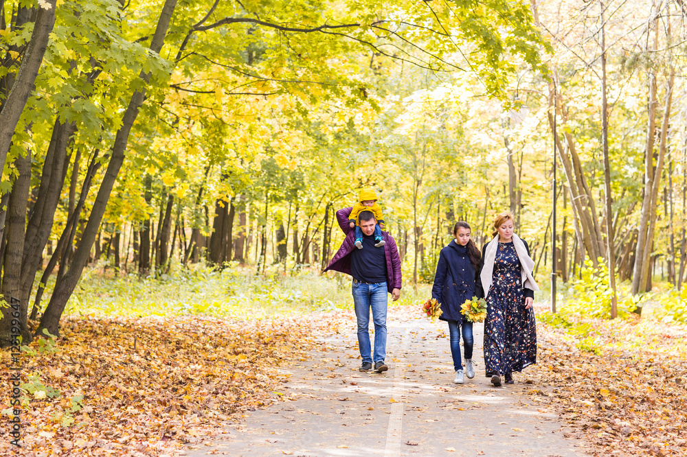 Happy young family spending time together outside in autumn nature.