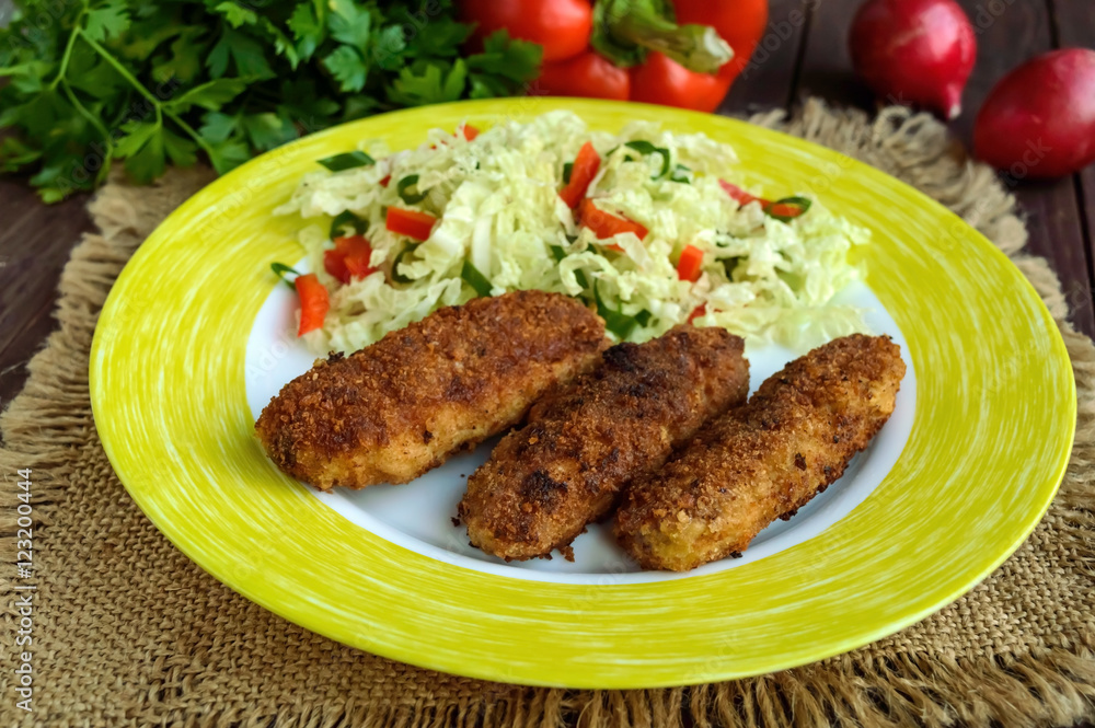 Meat cutlet with a salad of cabbage, peppers and herbs.