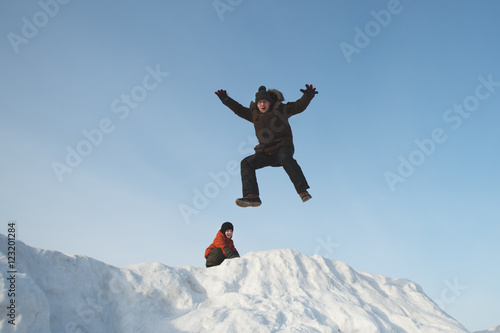 Папа и сын играют на снежной горке