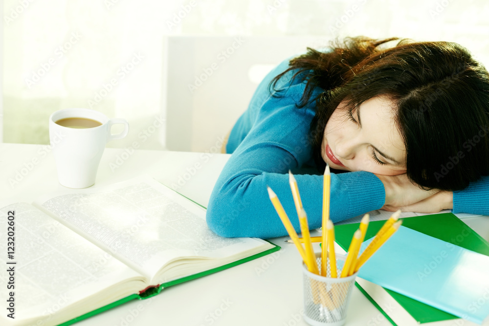 Young teenage girl falling asleep while doing homework Young teenage girl falling asleep while doing homework