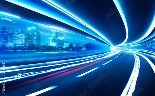 Abstract blurred speed motion road in glass tunnel over the city