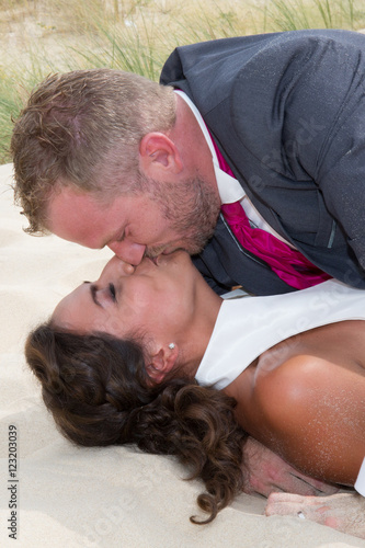 Happy bride and groom embracing lying on the wooden floor photo