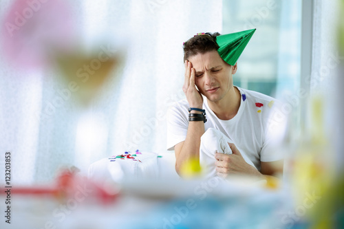 Fotografie Portrait of young man with a bad head after party