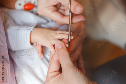 Сutting newborn baby nails with scissors 