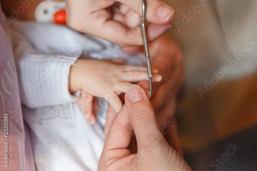 Сutting newborn baby nails with scissors 