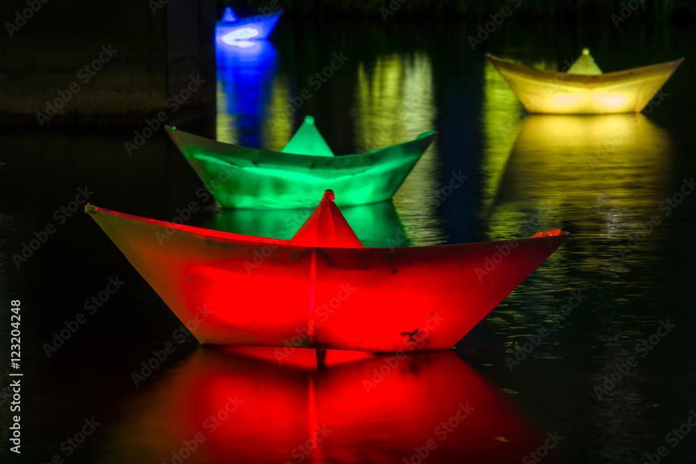 Paper illuminated boats on the water.
