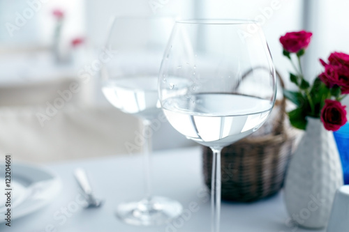 Close-up of elegant wine glasses with water on table 