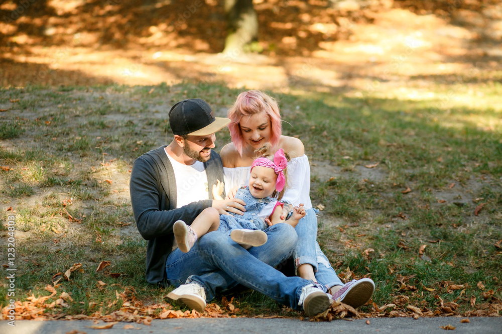 Fototapeta premium Sunshine illuminates happy stylish family playing on the lawn