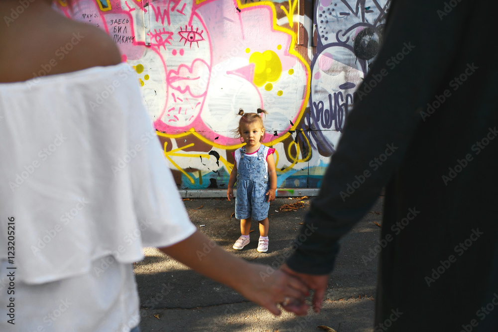 Look over man and woman holding each other hands at little child Look over man and woman holding each other hands at little child