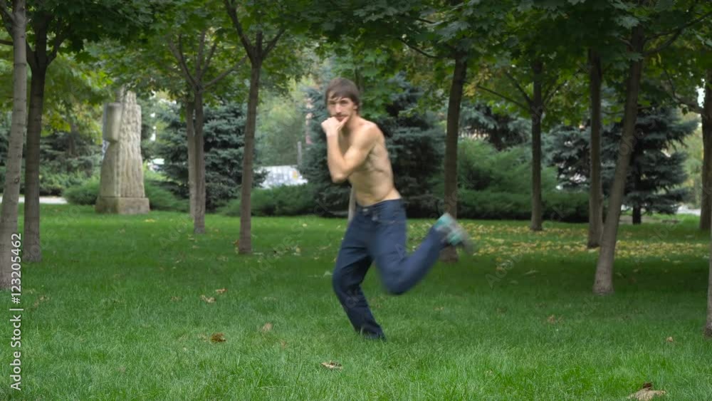 Young man dancing hip-hop and break dance in the park on the green grass. Young man dancing hip-hop and break dance in the park on the green grass.