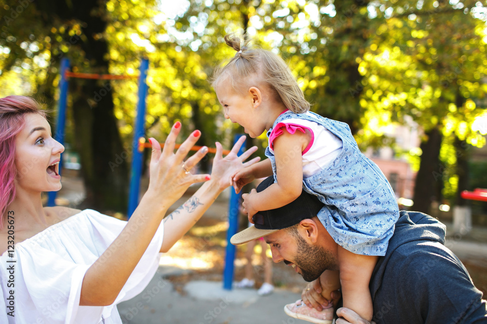Obraz premium Mother opens her hugs to little daughter held by father
