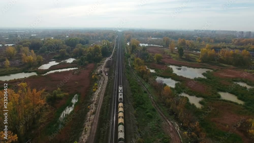 Flying over railway and freight train moving fast to horizon. Drone moving forward at at high altitude. 4K Aerial stock footage clip.
Flying over railway and freight train moving fast to horizon. Drone moving forward at at high altitude. 4K Aerial stock footage clip.