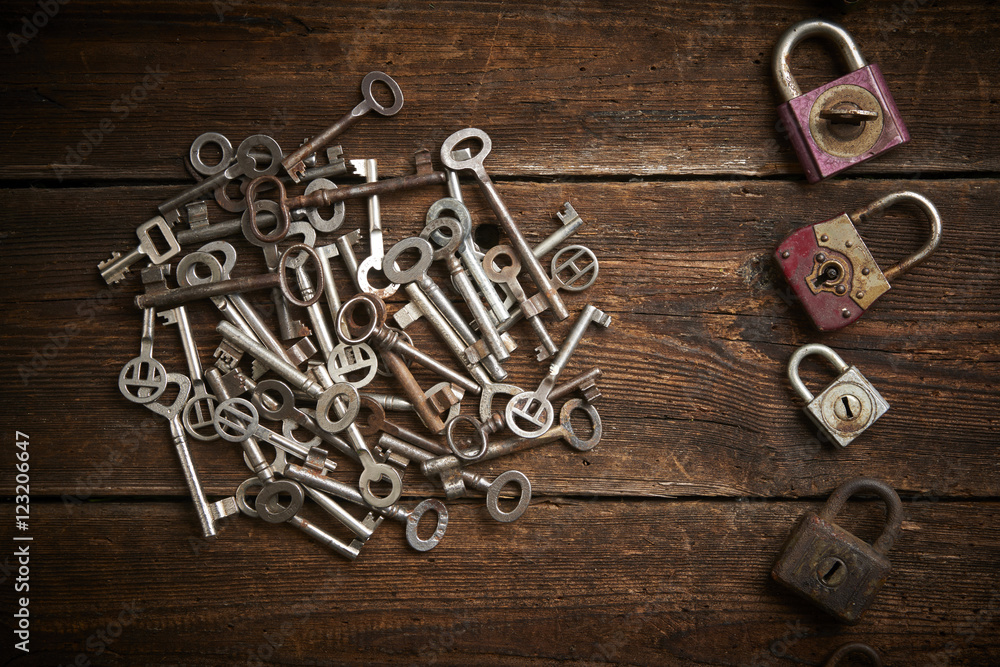 Group of old rusty padlocks with pile of keys on brown wooden table
Group of old rusty padlocks with pile of keys on brown wooden table