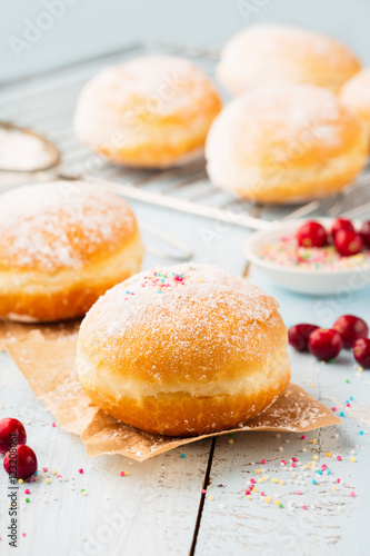 Wallpaper Mural Delicious freshly baked doughnuts with powdered sugar and fruit jam on blue wooden background. Breakfast concept Torontodigital.ca