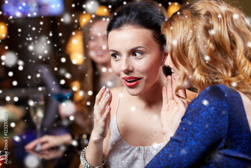 happy women gossiping at night club over snow © Syda Productions