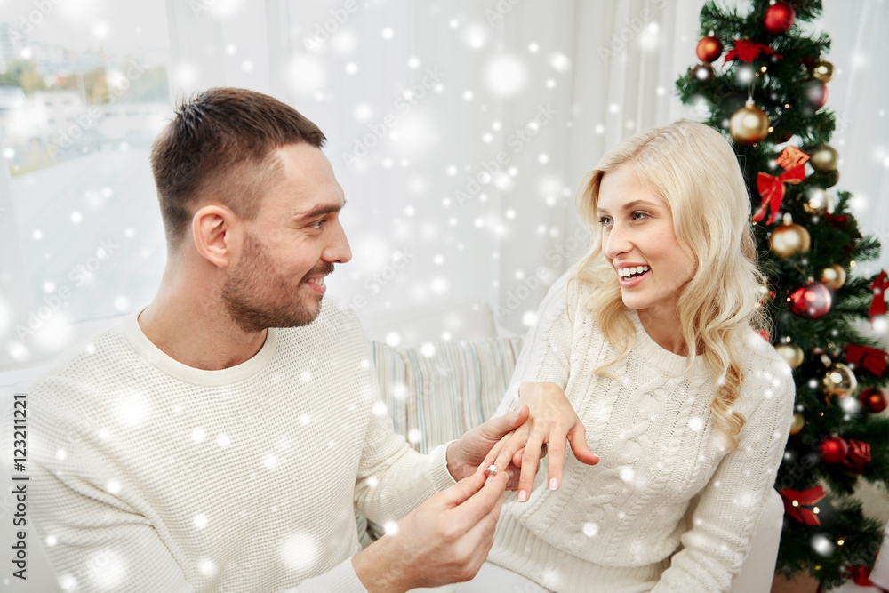 man giving engagement ring to woman for christmas man giving engagement ring to woman for christmas
