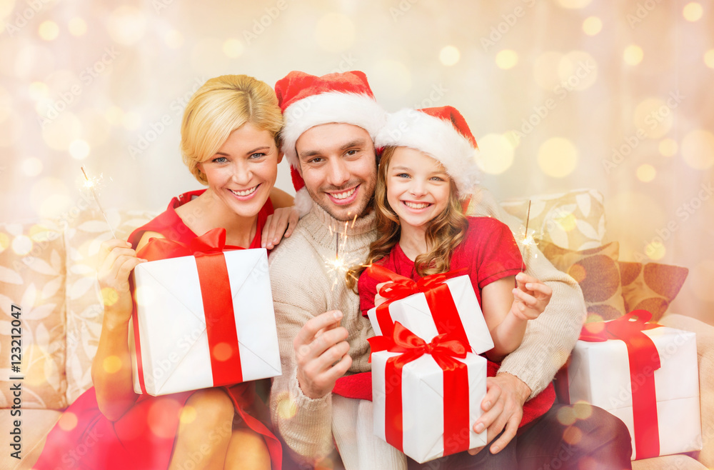 smiling family holding gift boxes and sparkles smiling family holding gift boxes and sparkles
