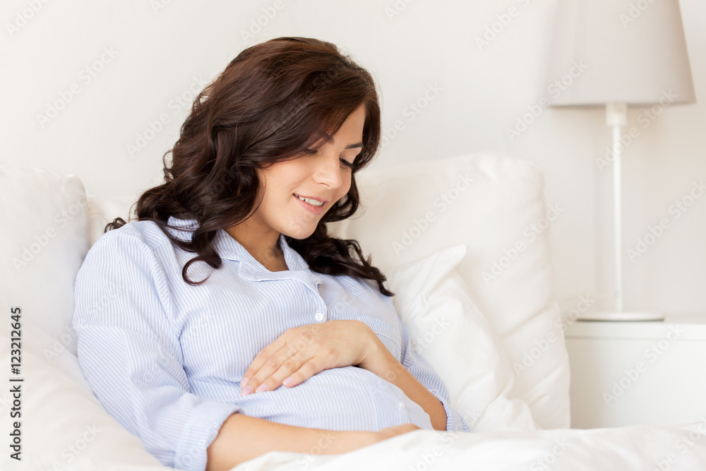 happy pregnant woman lying in bed at home happy pregnant woman lying in bed at home