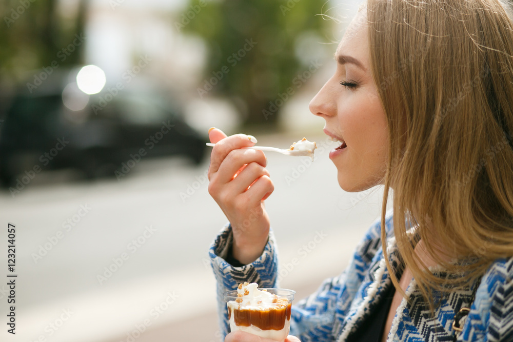 Profile of young woman eating tasty ice-cream Profile of young woman eating tasty ice-cream