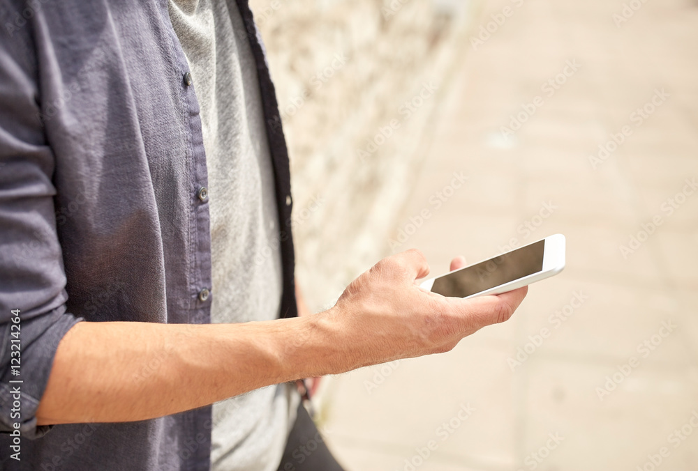close up of man with smartphone at stone wall