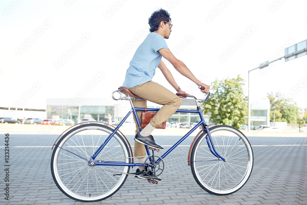 Naklejka premium young hipster man riding fixed gear bike