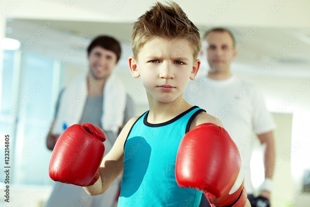 Little serious boys in boxing gloves looking at camera