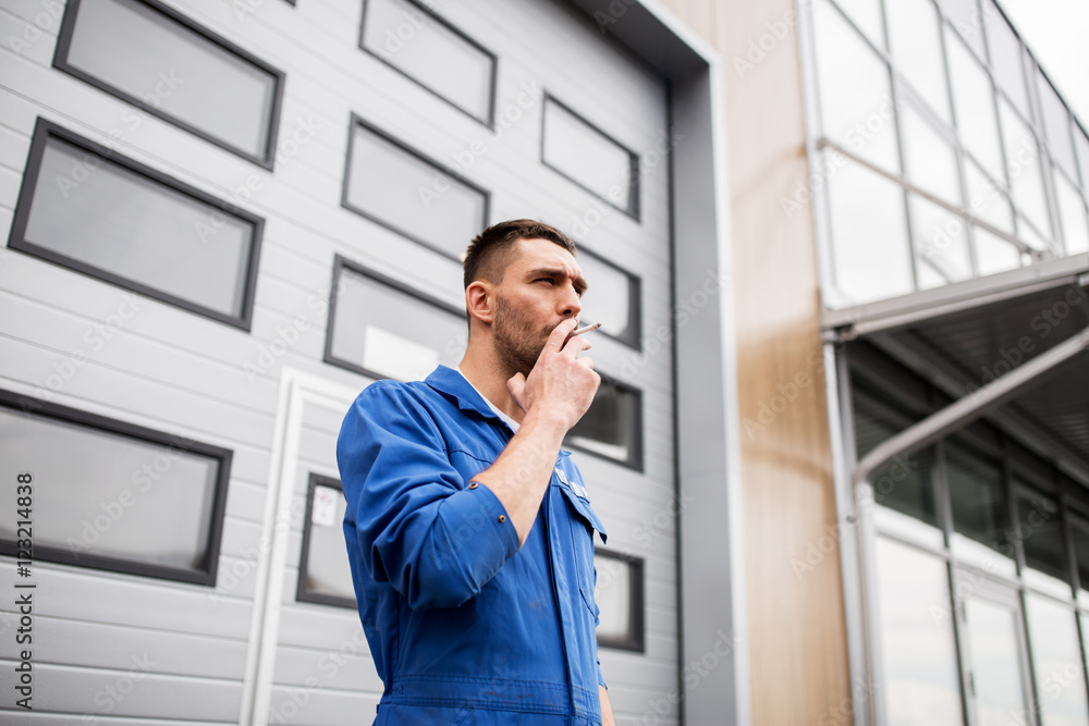 auto mechanic smoking cigarette at car workshop auto mechanic smoking cigarette at car workshop
