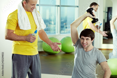 Young men training at gym with instructor