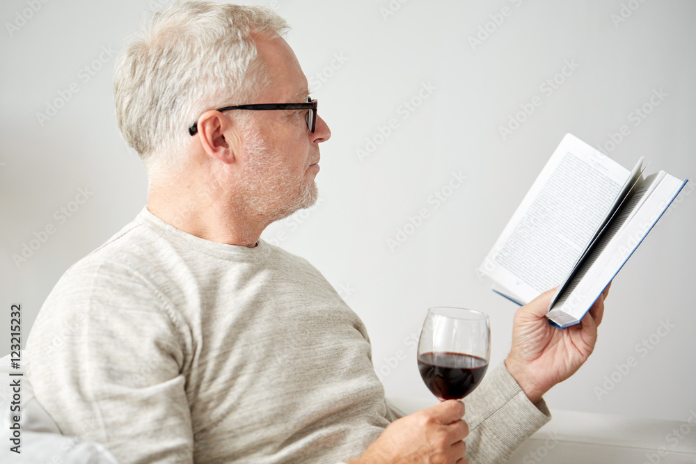 senior man drinking wine and reading book senior man drinking wine and reading book