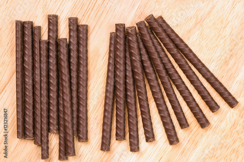 chocolate sticks lie on a wooden surface abreast. chocolate dessert. neatly folded sweetness