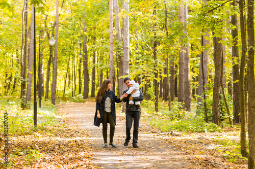 Young couple with newborn baby outdoors in autumn