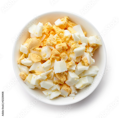Bowl of chopped boiled egg, isolated on white, from above