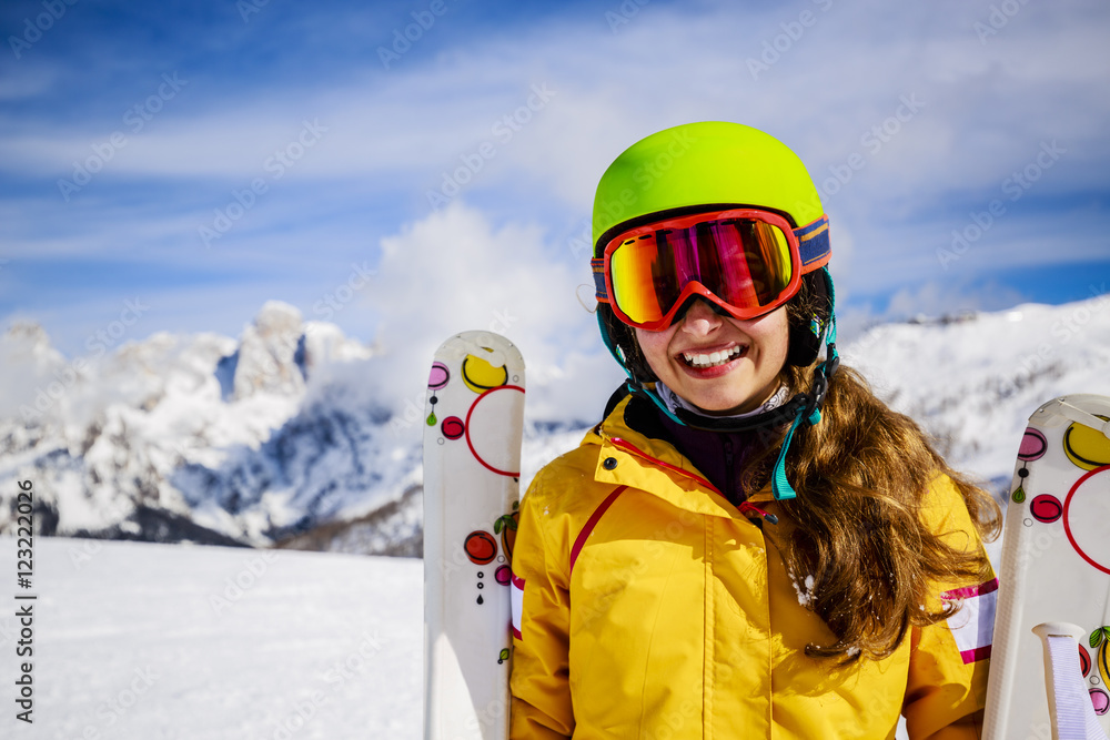 Smiling girl standing with ski and  arms spreading wide open on