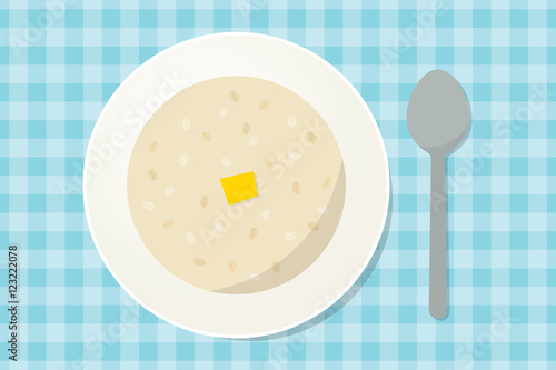 Oatmeal porridge with a piece of butter in a plate with spoon. Healthy breakfast