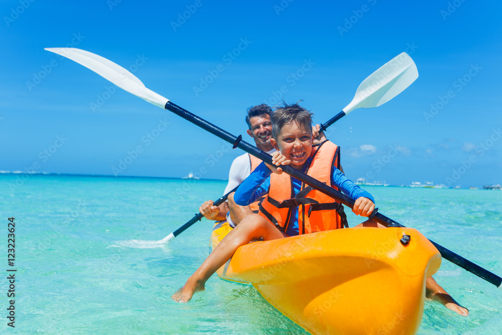 Father and son kayaking at tropical ocean